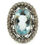 An 18ct white gold and single stone oval cut aquamarine set dress ring, with brilliant cut diamond