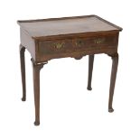 A George II oak side table, c.1750, the rectangular moulded top above a drawer and shaped apron,