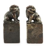 A pair of Chinese soapstone lion-dog seals, Qing dynasty, with vacant matrices, the dark grey