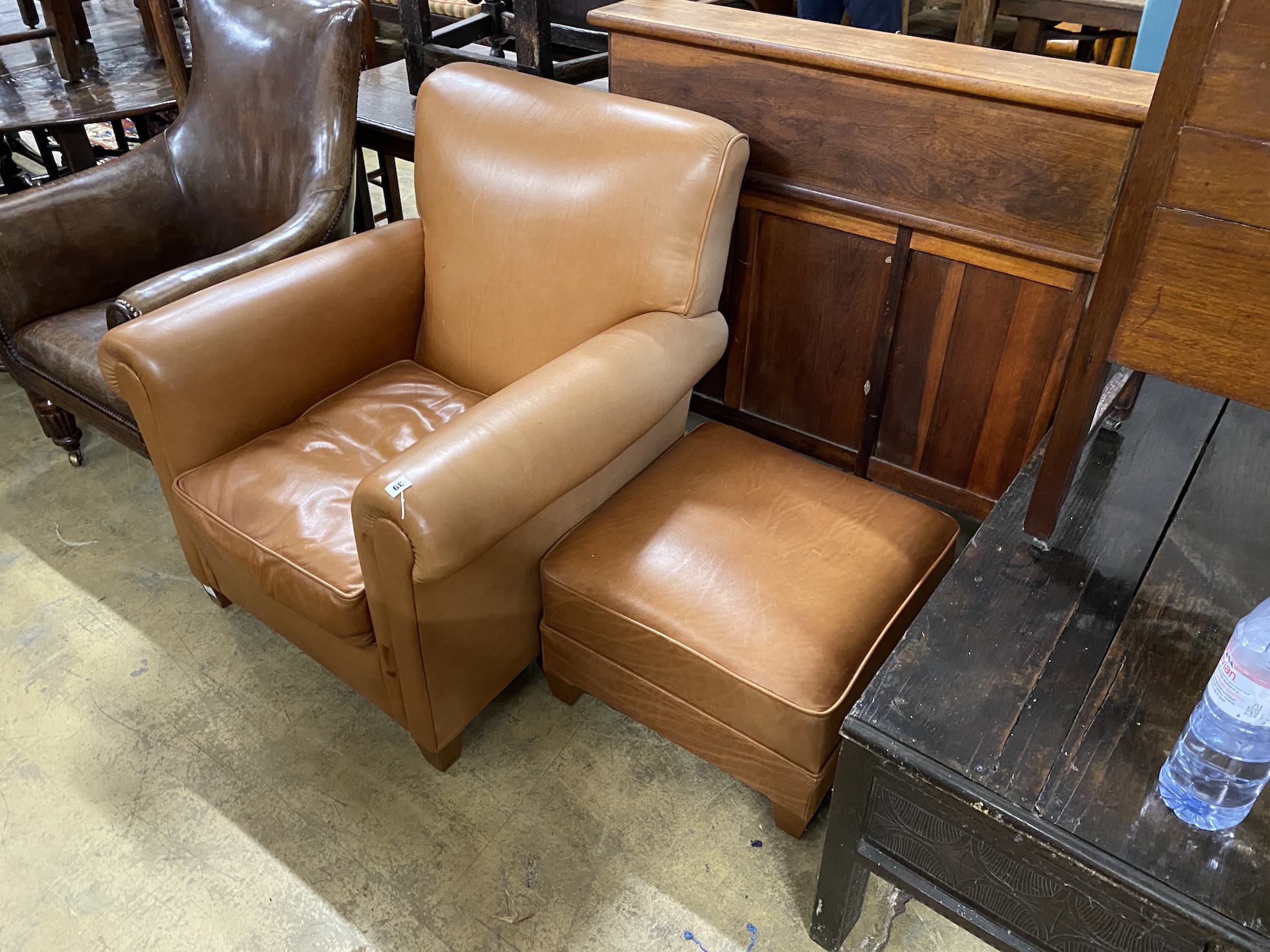 A contemporary brown leather upholstered armchair, width 84cm, depth 86cm, height 90cm and a