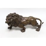 A hollow cast bronze model of a lion, 33cm long