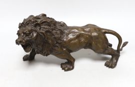 A hollow cast bronze model of a lion, 33cm long