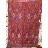 A North West Persian Jadjim geometric red ground carpet 284cm x 140cm