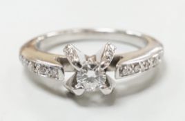 A modern 18ct white gold and claw set single stone diamond ring, with diamond chip set shoulders,