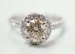 A modern platinum and single stone diamond set ring, with diamond chip set border and shoulders,