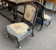 A pair of late Victorian ebonised and amboyna salon chairs with petit point upholstery, width