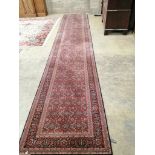 A machine made Belgian, North West Persian style, red ground runner approximately 540cm x 100cm