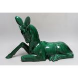A French Art Deco large green glazed ceramic model of a seated deer, 50cm wide