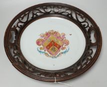 An 18th century Chinese armorial dish, rim cut down and mounted in a 19th century English mahogany
