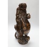 A carved oak lion holding a shield with inscription, possibly 17th/18th century with Victorian