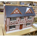 A painted doll's house with dolls and furniture, dolls house 78.5cm wide, 67cm high