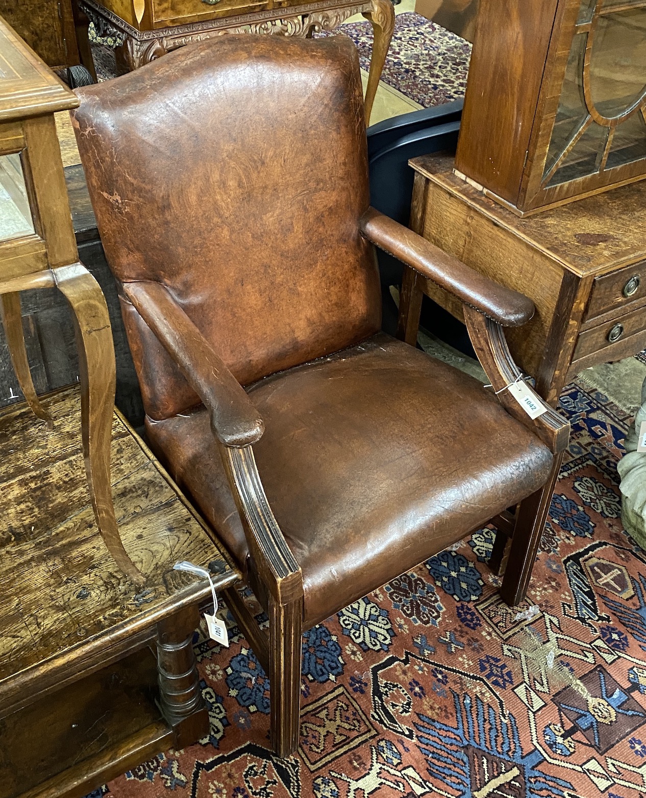 A George III style tan leather beech Gainsborough style chair, width 60cm, depth 56cm, height 95cm