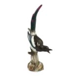 A tall Meissen figure of a magpie, 19th century, perched on a tree stump, incised model no. 62,