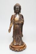 A Chinese gilt lacquered bronze standing figure of Buddha on stand, 31cm high not including stand