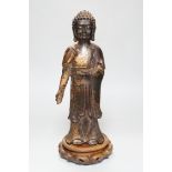 A Chinese gilt lacquered bronze standing figure of Buddha on stand, 31cm high not including stand