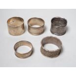 Five assorted silver napkin rings.