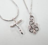 A modern 18ct white gold and three stone diamond set scroll pendant, 20mm, on an 18ct white gold