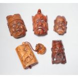 A group of hardwood models of noh masks and a similar inro, 9cm and netsuke