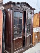 An early 20th century continental oak bookcase, lacking shelves and interior drawers, width 143cm,