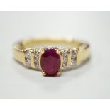 A modern yellow metal and single stone oval cut ruby set dress ring, with ten stone diamond chip set