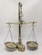 A set of dolphin decorated brass scales and a set of weights, 61cm high