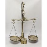 A set of dolphin decorated brass scales and a set of weights, 61cm high