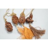 Two Chinese peach stone carvings and two carved wood toggles on a silk cord