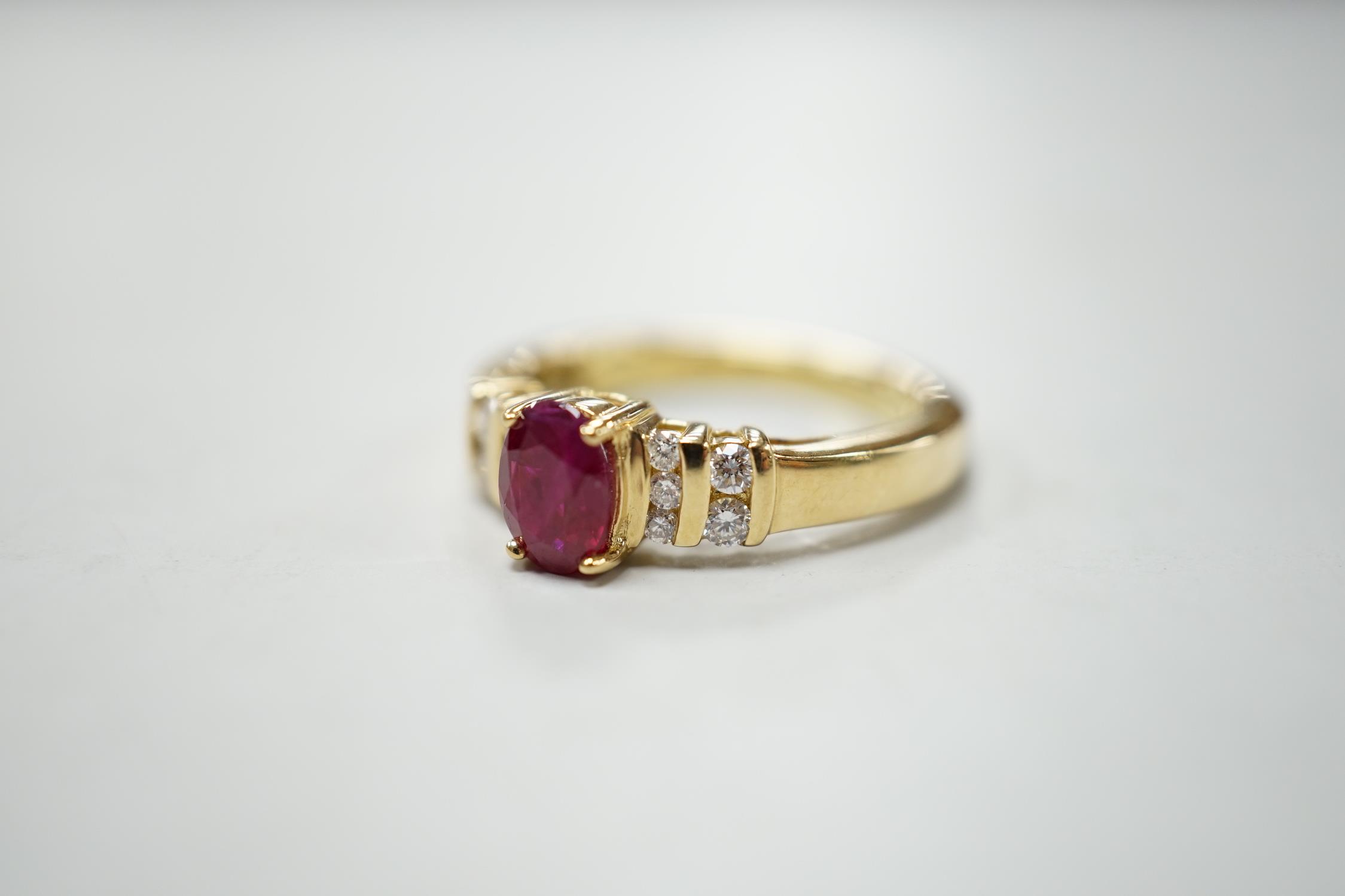 A modern yellow metal and single stone oval cut ruby set dress ring, with ten stone diamond chip set - Image 2 of 3
