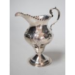 A George III silver inverted pear shaped cream jug, maker H?, London, 11.2cm, 75 grams.