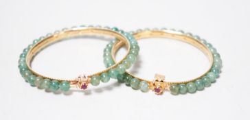 A pair of yellow metal and jade bangles, 7.2cm diameter