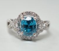 A modern 14k white metal, cushion cut blue zircon and diamond chip set cluster dress ring, with
