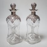 A pair of late Victorian repousse silver mounted hour glass decanters and stoppers, Henry