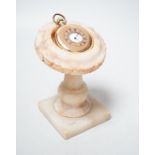 A gold plated pocket watch and carved alabaster stand, total height 14 cm
