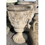 A pair of large circular reconstituted stone garden planters, moulded with a band of putti on square