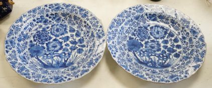 A pair of Chinese Kangxi blue and white dishes, painted with rock work and flowers, artemisia leaf