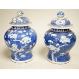 A pair of Chinese blue and white prunus pattern vases and covers, 21cm high