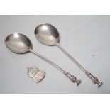 A pair of Edwardian silver apostle spoons, London, 1906 and an ARP badge