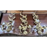 A set of three gilt metal floral two branch wall lights