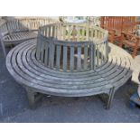 A weathered teak circular two section tree seat, diameter 220cm, inner diameter approximately 110cm,
