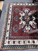 A Caucasian design burgundy ground rug 220cm x 148cm