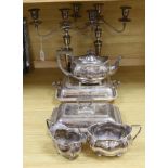 A group of silver plated items including a pair of three branched candlesticks, teapot, milk jug and