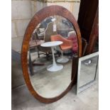 An early 20th century French oval amboyna wall mirror, width 138cm, height 88cm