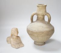 An Egyptian style alabaster model of a sphinx and a twin handled pottery vase, the largest 25cm