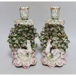 A good pair of Derby candlestick figures of rabbits before a brocage, the elaborate sconce