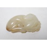 A Chinese pale celadon jade hound plaque, 5.2 cm