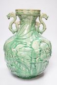 A Chinese green glazed vase with twin zoomorphic handles, decorated in relief with dragons, 35cm