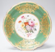 An English porcelain large bowl the centre painted with a bouquet of flowers under a green border