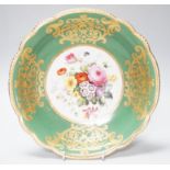 An English porcelain large bowl the centre painted with a bouquet of flowers under a green border