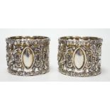 A pair of Edwardian silver serviette rings, pierced and embossed with deer hunting scenes,