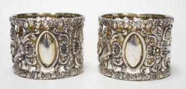 A pair of Edwardian silver serviette rings, pierced and embossed with deer hunting scenes,